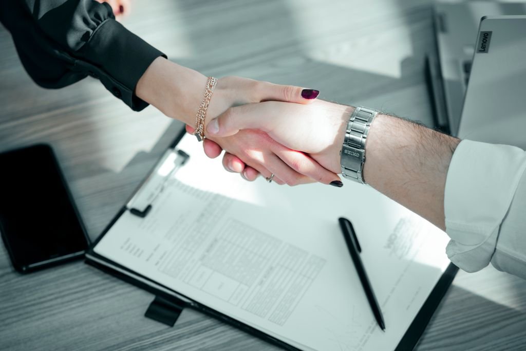 Two people signing documents at a desk