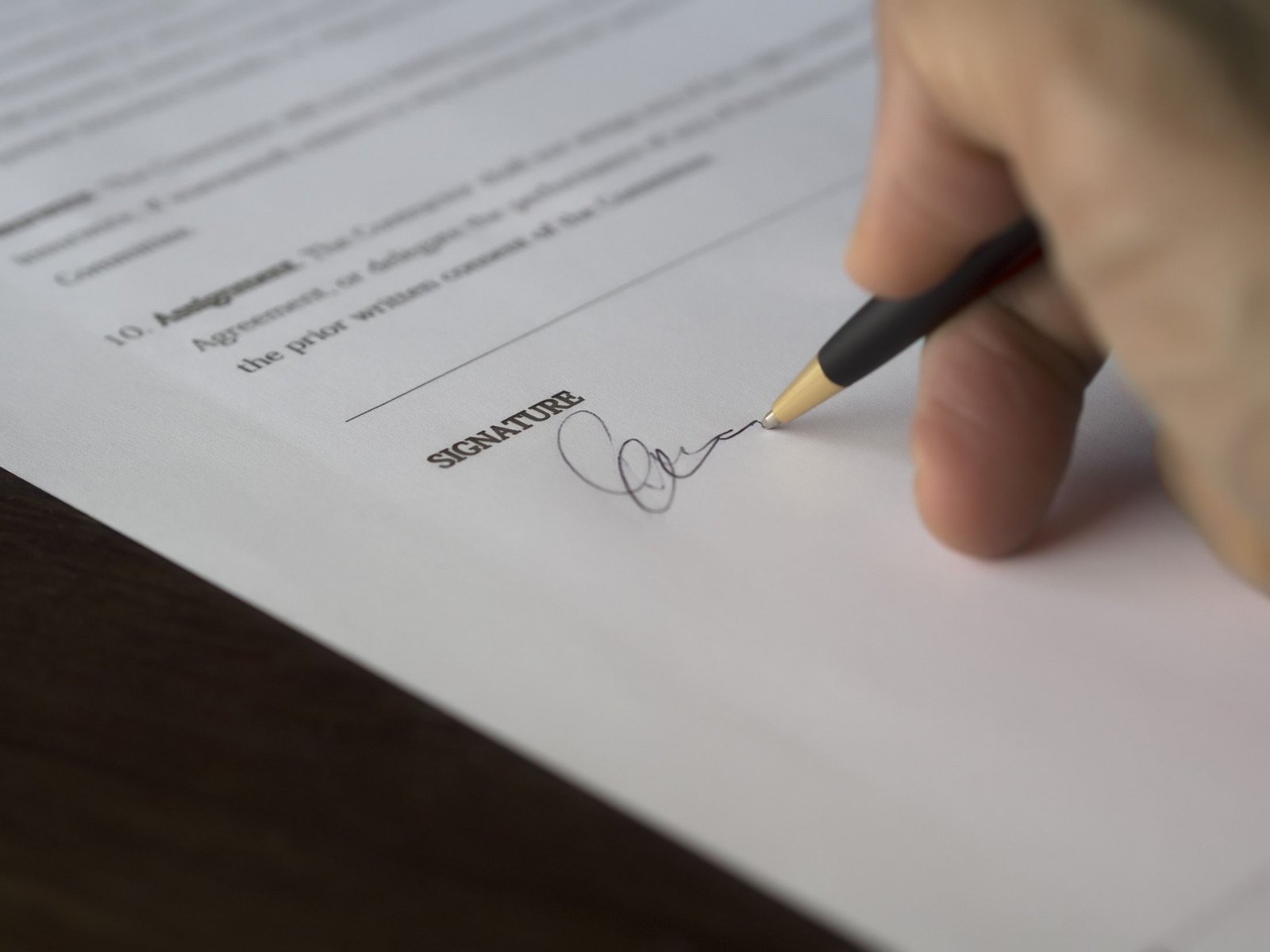A contract being signed with a fountain pen