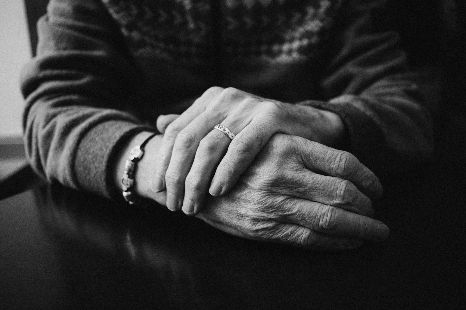 Two pairs of hands held together, in black and white