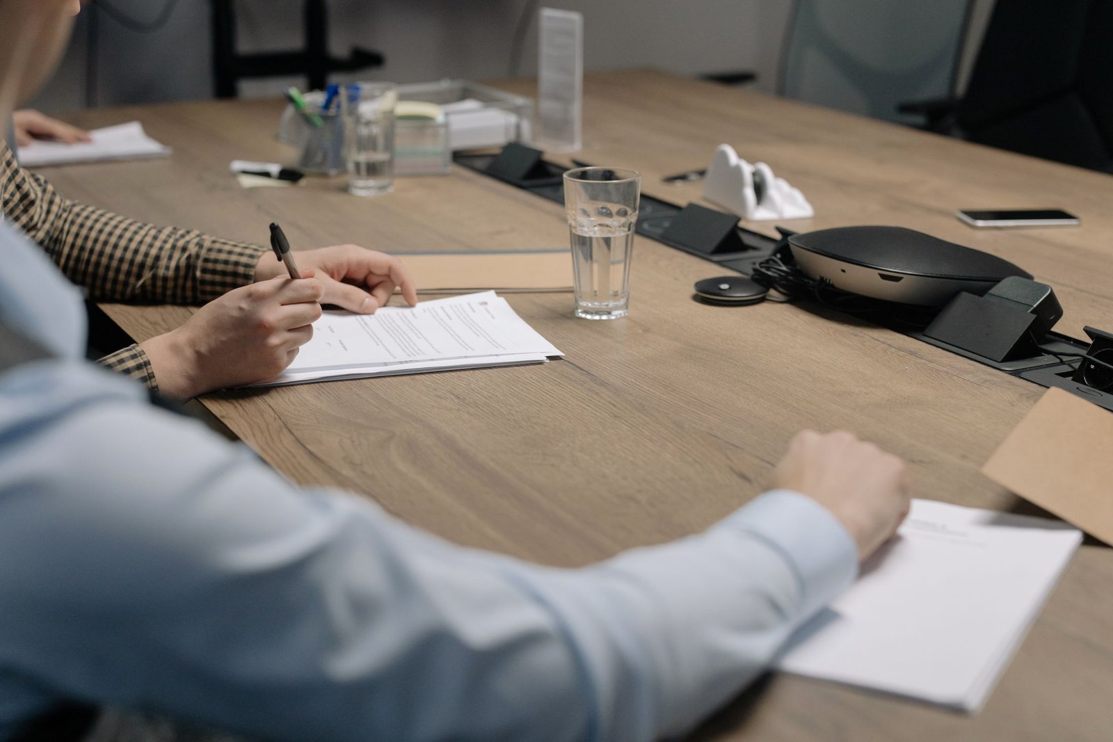 People signing documents across a conference table