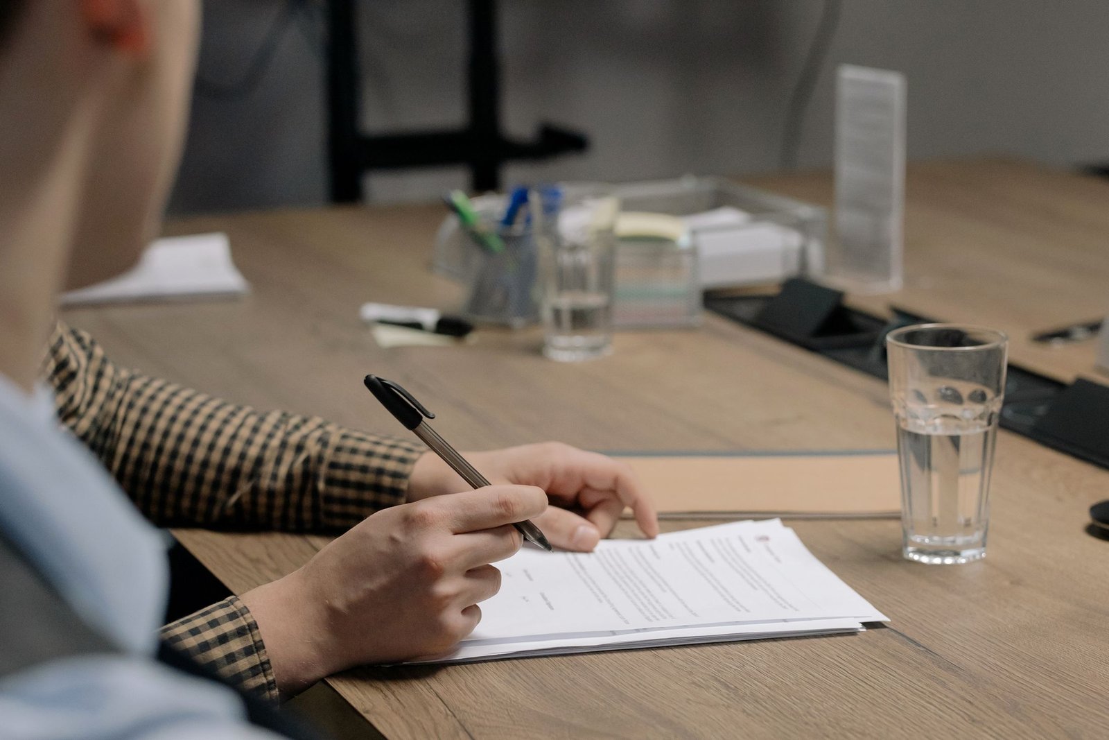 A person signing a document at a desk