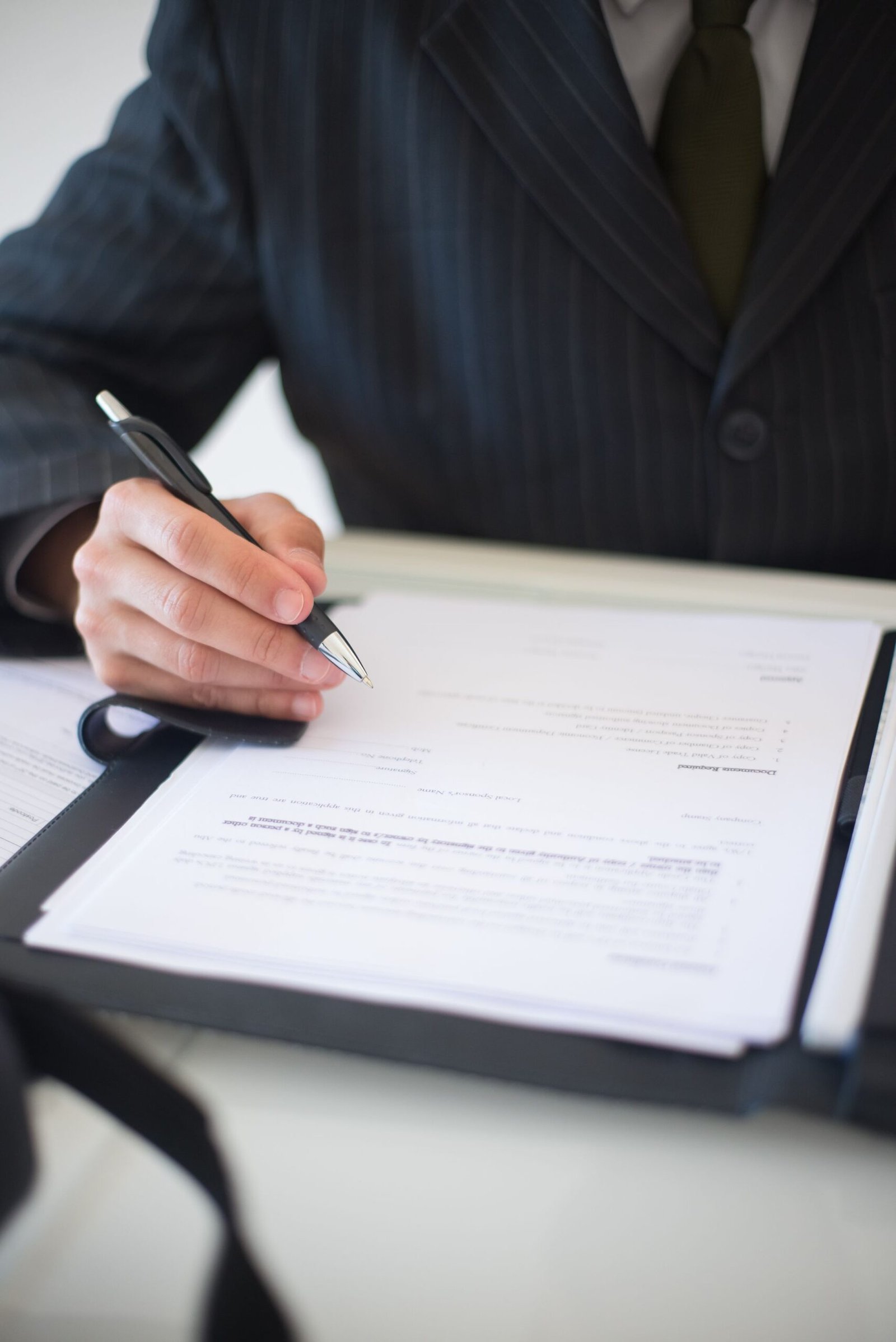 A hand signing a document, close in