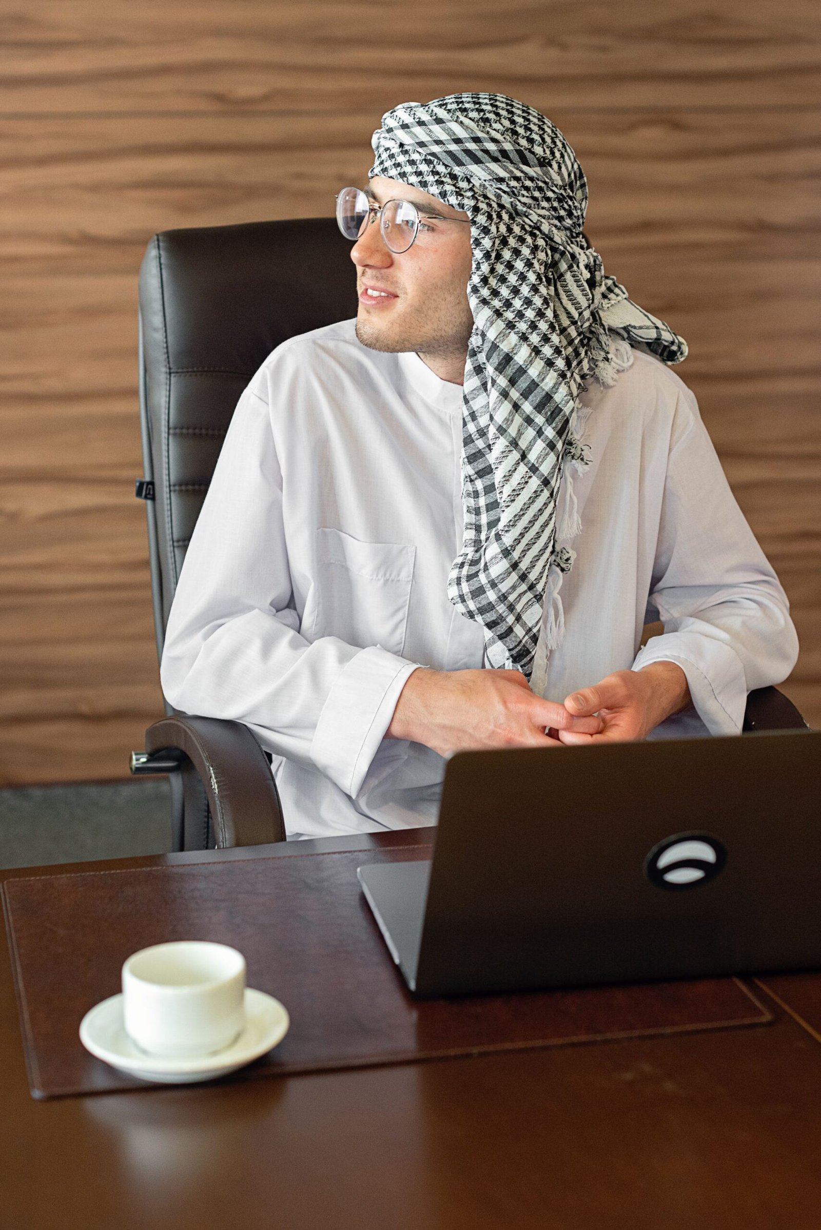 رجل يرتدي كندورة يعمل على مكتب