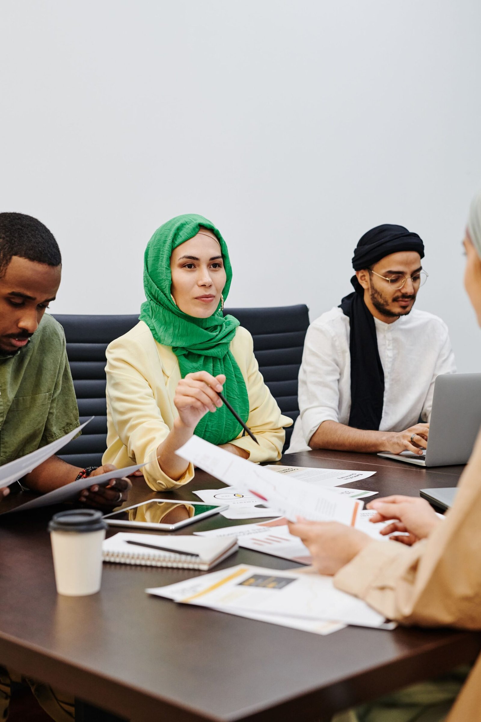 فريق يجلس حول طاولة وأمامهم أوراق
