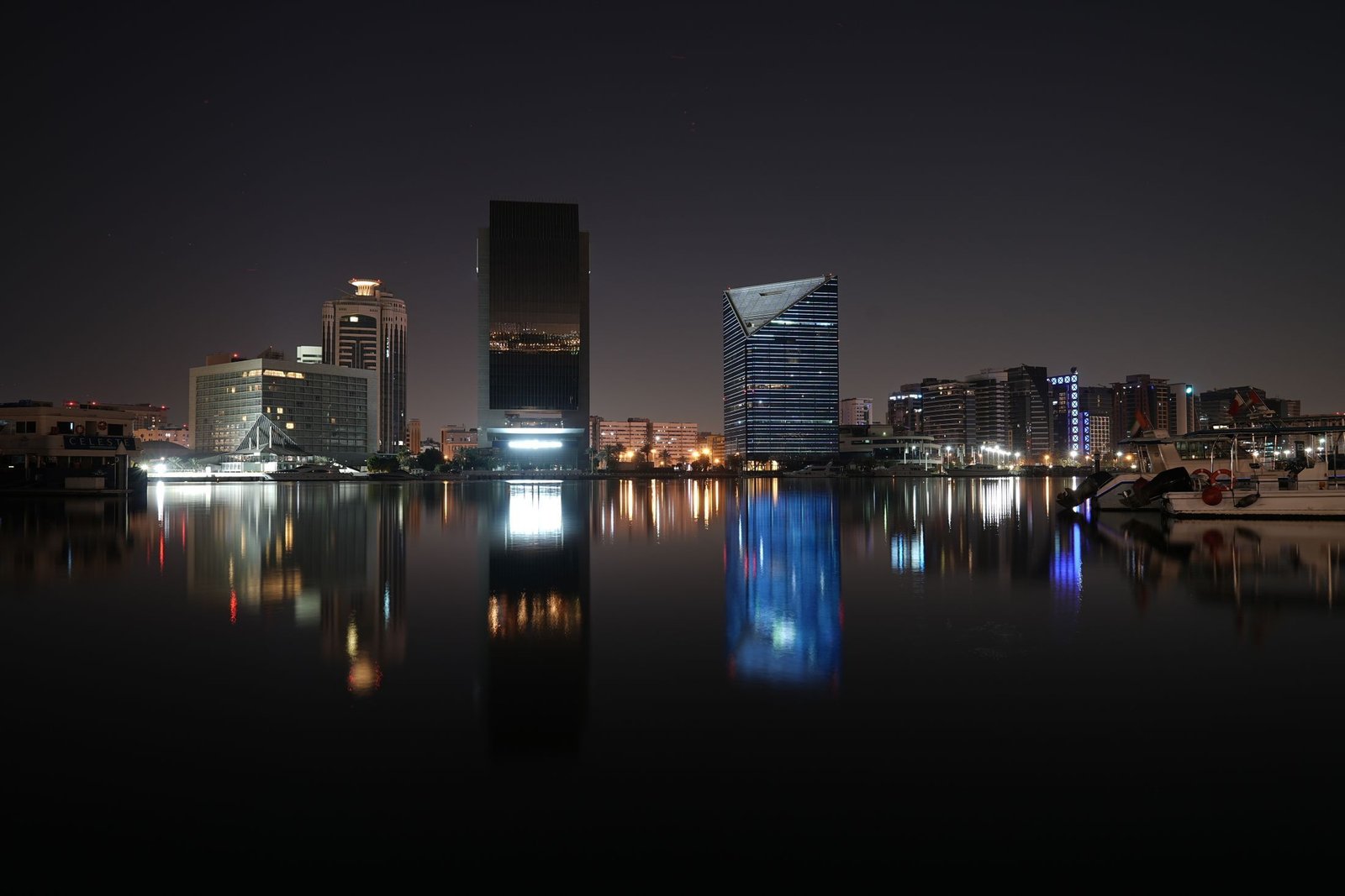 Dubai Creek at night, office towers reflected in the dark water